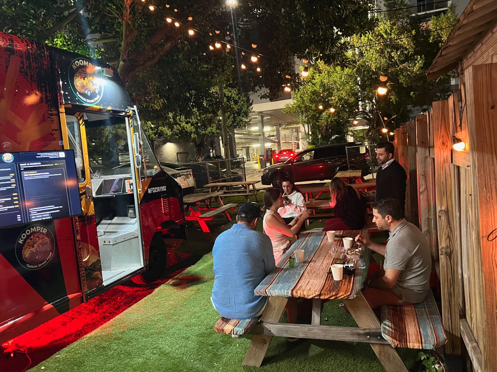 Customers dining at Koompir outdoor garden at night Miami