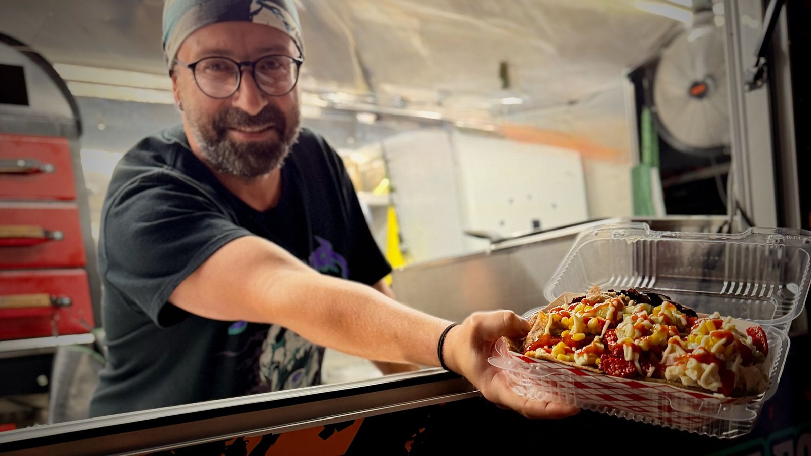 Chef serving fresh kumpir from Koompir food truck window