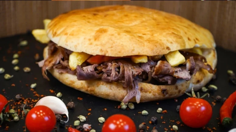 Tombik doner kebab sandwich with sauce and fresh vegetables - Turkish street food Miami